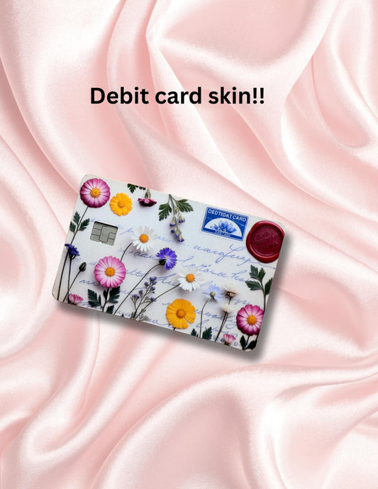 Beach-themed debit card skin with an illustration of an open book, coffee cup, seashells, and ocean waves. Displayed on a pastel pink background with soft floral graphics. Ideal for book lovers, beach vibes, and dreamy aesthetic fans looking for a vinyl card cover or cute credit card sticker.